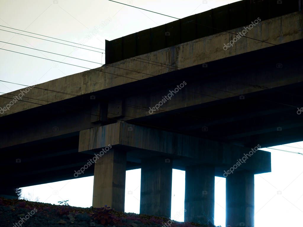 Industrial image of cemented bridge with sunlight reflection with electric wire on sky background