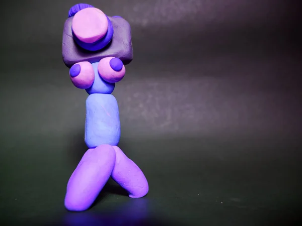 Funny cartoon camera tripod made with clay art on black background