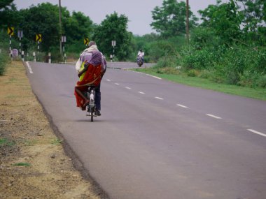Hintli erkek ve kadın bisiklet taşımacılığıyla birlikte yola çıkıyorlar..