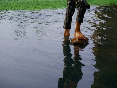 Su yansıması üzerine gölgesi olan çocuk bacağı Çocuk yaşam tarzı konsepti için sunum.