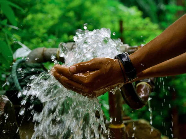 Junge Hand Sammelt Wasser Wasserhahn Bei Grünem Naturunschärfe Hintergrund — Stockfoto