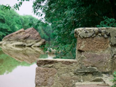 Nehir kıyısının doğal zemininde taş merdiven yapısı var..