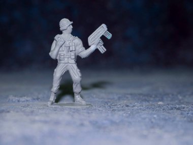 Ordu komandosu saldırı pozisyonunda duruyor. Mavi arka planda izole edilmiş, çocuklar nesnelerin doğal görüntülerini oynuyorlar..