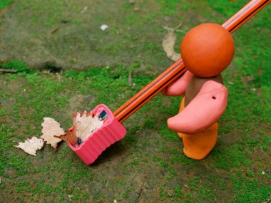 Yeşil doğal alandaki bileyiciden kalem keskinleştiren yumuşak kilden oyuncak adam, eğitim imajı kavramı.