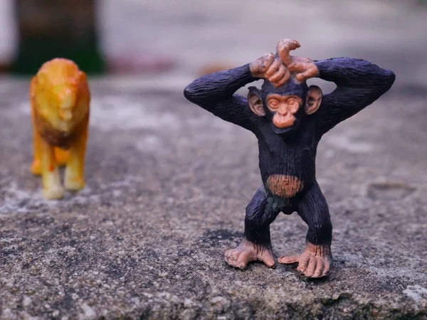 Monkey toy standing in front behind lion coming, kids playing animal toy image.