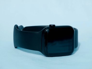 Beyaz arkaplanda sunulan siyah renkli dijital akıllı saat.