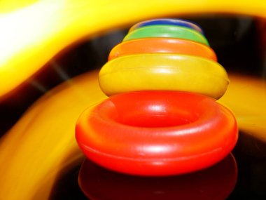 Çocuklar plastik oyuncak dairesel blokları sarımsı ışık efekti arka planıyla sıralıyorlar.