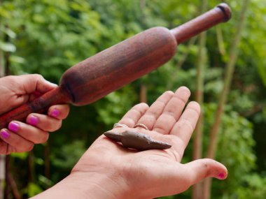 Ahşap Chapati silindiri, yeşil doğal çevreye kıyasla elinizdeki toprak yapımı oyuncakla sunuluyor..