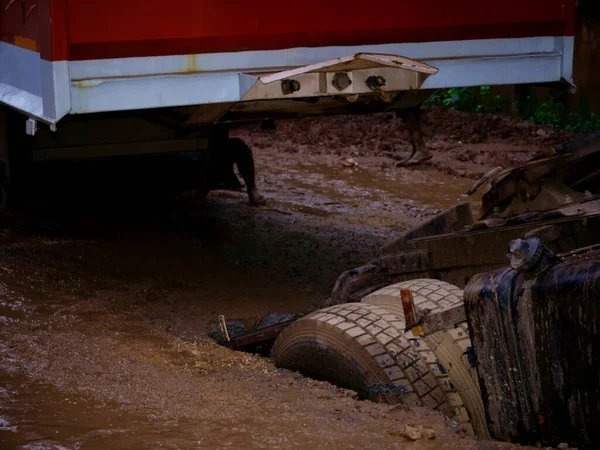 Indian Lorry truck Collapse on road during raining season on mud dirty field, Accidental transport background image.