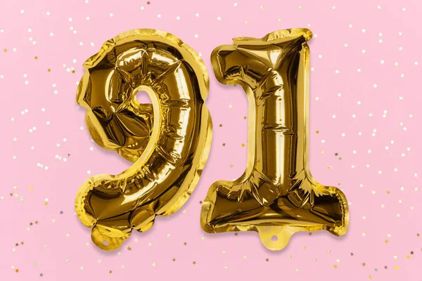 The number of the balloon made of golden foil, the number ninety-one on a pink background with sequins. Birthday greeting card with inscription 91. Numerical digit, Celebration event, template.