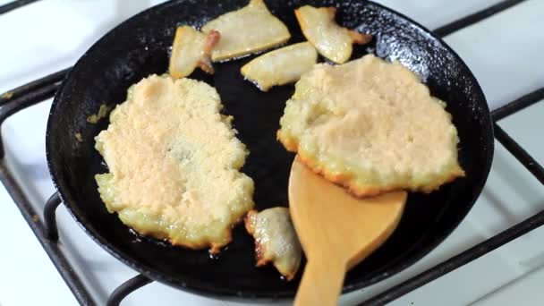 Cooking potato pancakes in a frying pan with bacon — Stock Video