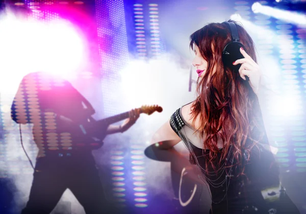 Kulaklık ile müzik dinlemek güzel bir kadın. Gitar ve parlak ışıklar sahnede canlı müzik arka plan.