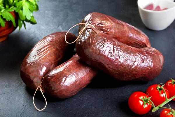 Salsicha de sangue fresco não cozida com salsa e tomate. porco cru pronto para cozinhar — Fotografia de Stock