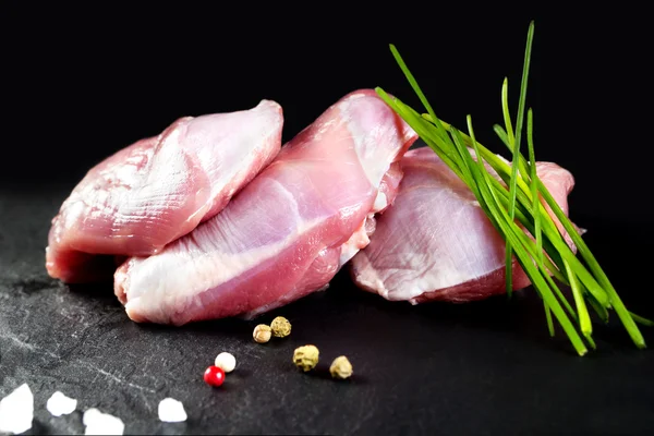 Carne cruda y fresca. Muslos de pollo y muslos sin piel fresca. fondo de piedra negro —  Fotos de Stock