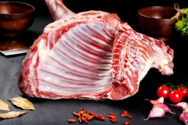 Taze ve çiğ et. Bilbo'yu pişmemiş kaburga ve ızgara için kızartma Barbekü pirzola. Siyah taş arka plan domates ve biber ile