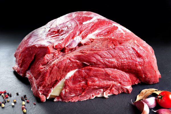 Fresh and raw meat. Whole piece of red meat ready to cook on the grill or BBQ .Background black blackboard
