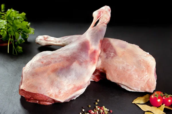 Vers en ruwe vlees. Been van lamb ongekookt tomaat en peper op zwarte achtergrond — Stockfoto