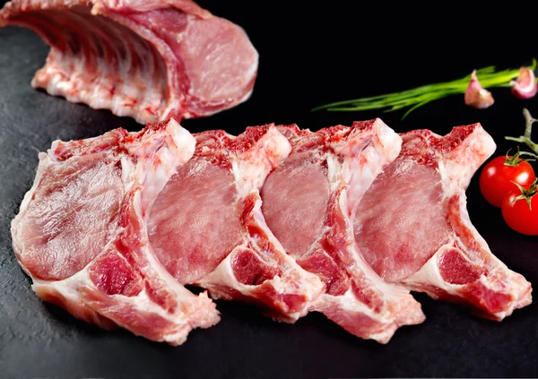 Carne fresca e crua. Costelas e costeletas de porco não cozidas, com cortes prontos para grelhar e churrasco — Fotografia de Stock