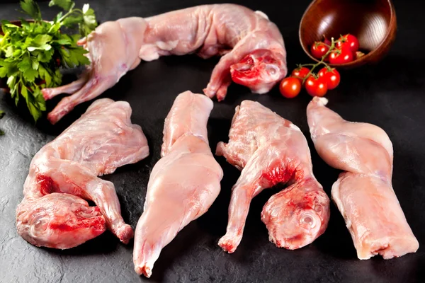 Rohes und frisches Fleisch. Kaninchen bereit zum Kochen. schwarzer Hintergrund — Stockfoto