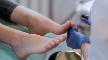 Tırnak törpüsü matkabıyla donanım tıbbi pedikür. Pediyatrist ayak hastalıkları uzmanıyla pedikür tedavisi gören hasta. Özel bir cihazla kaplıcada ayak soyma tedavisi. Podoloji Kliniği.