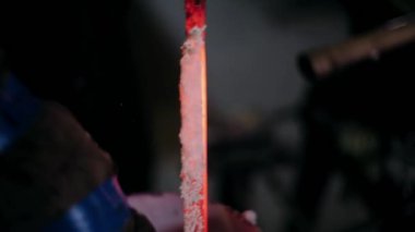 Demirci metalle çalışır. Demirci gemisi... demircinin elleri kızgın metali dövüyor ve her yöne kıvılcımlar saçıyor.