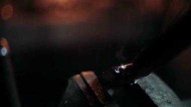 Demirci metalle çalışır. Demirci gemisi... demircinin elleri kızgın metali dövüyor ve her yöne kıvılcımlar saçıyor.