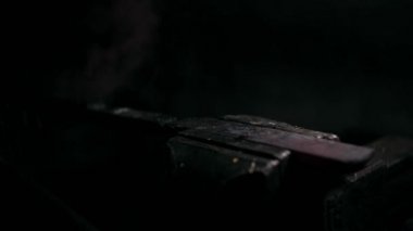 Demirci metalle çalışır. Demirci gemisi... demircinin elleri kızgın metali dövüyor ve her yöne kıvılcımlar saçıyor.