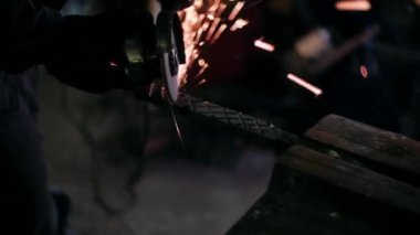 Öğütücüyle öğütülmüş metal. Demirci metalle çalışıyor. Demircilik teknesi..