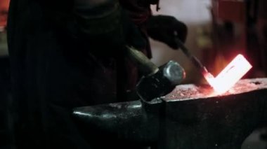 Demirci metalle çalışır. Demirci gemisi... demircinin elleri kızgın metali dövüyor ve her yöne kıvılcımlar saçıyor.