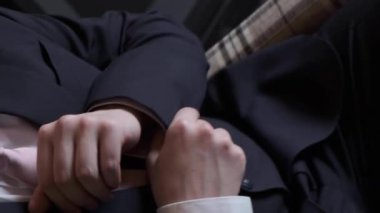 İş adamı gömlek kollarının düğmelerini ilikliyor, yakın plan. Beyaz gömlekli başarılı bir adam kollarına düğme takar, yakın plan, erkek eli beyaz gömleği ilikler.