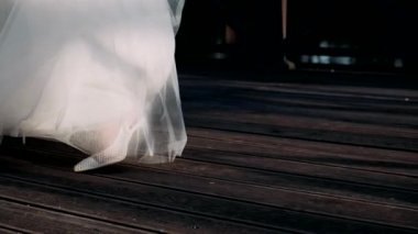 Topuklu ayakkabılı kadınların bacakları gelinlik içinde dönüyor.