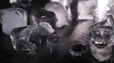 Buz arasında alyanslar. Buz parçalarının arasında Elmaslarla Odak Noktası Alyansları ve Elmaslar. Buz küpü. Kapat.