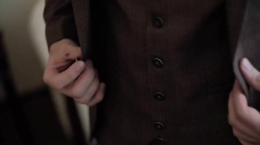 Kahverengi takım elbiseli adam kutlama için hazırlanıyor.