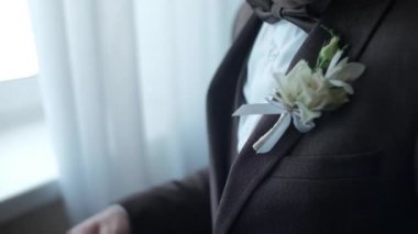 Kahverengi takım elbiseli adam kutlama için hazırlanıyor.