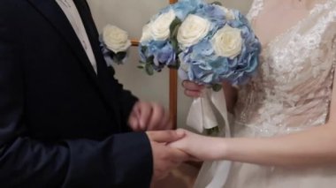 Damat gelinin elini tutar.