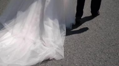 Gelinin ve damadın ayakları yolda yürüyor.