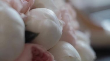 Düğün buketi dolusu taze beyaz Peonie. Düğün takıları peçe ile örtülü kadın ayakkabılarının yanında. Ayakkabılar cama yansıyor. metin eklenecek bir yer var