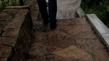 Damat ve gelin ayaklarındaki asfalt çerçevede yürüyorlar.