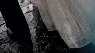 Damat ve gelin ayaklarındaki asfalt çerçevede yürüyorlar.