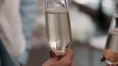 Ellerinde bardakları olan insanlar bir büfede sohbet ediyorlar. Bağ Başlığı: Kutlama, şampanya ve kadeh kaldırma günbatımında kadeh tokuşturan insanlarla parti, dostluk ve çatıda mutlu anlar