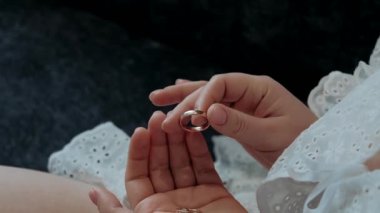 Altın alyansları tutan kadınların yakın plan fotoğrafları.