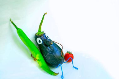 Patlıcan beyazı arka plandan komik bir figür. Sebzelerle dekoratif bir çalışma örneği. Sonbahar hasadı.