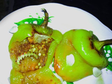 Solucanlı tatlı biber, kırmızı biber, tabakta kızartılmış, ürpertici bir arka plan.