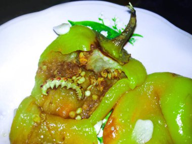 Solucanlı tatlı biber, kırmızı biber, tabakta kızartılmış, ürpertici bir arka plan.