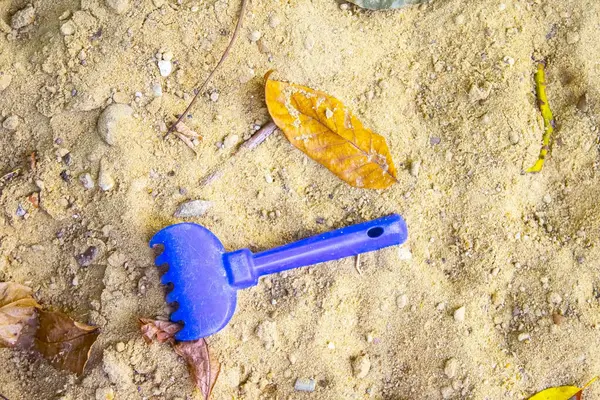 蓝色的婴儿铲 沙上有阴影 孤独的童年概念 — 图库照片