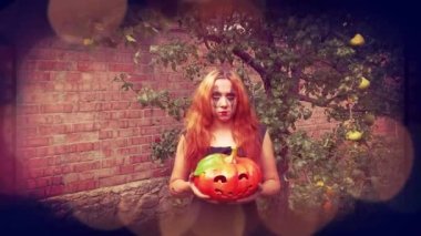 Genç seksi cadı elinde oyulmuş bir balkabağı, cadılar bayramı geçmişi