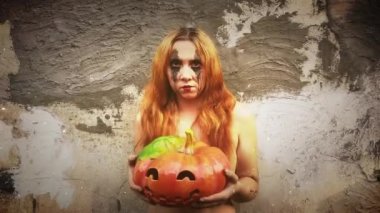 Genç seksi cadı elinde oyulmuş bir balkabağı, cadılar bayramı geçmişi