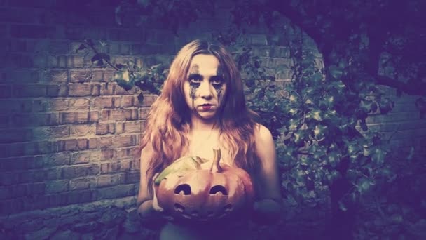 若いですセクシー女性魔女保持A彫刻カボチャ ハロウィンの背景 — ストック動画