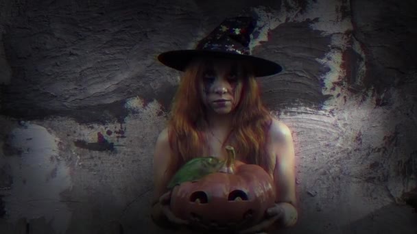 年轻性感的女巫手里拿着一个雕刻的南瓜万圣节背景 — 图库视频影像