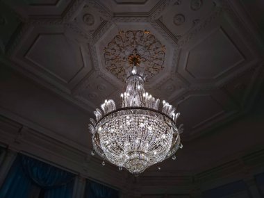 Büyük, modern avize, taklit mumlar ve büyük kristaller.